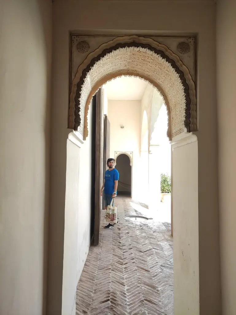 Ayal Othman standing beneath an ornate stone archway, reflecting exploration, architecture, and creative inspiration.