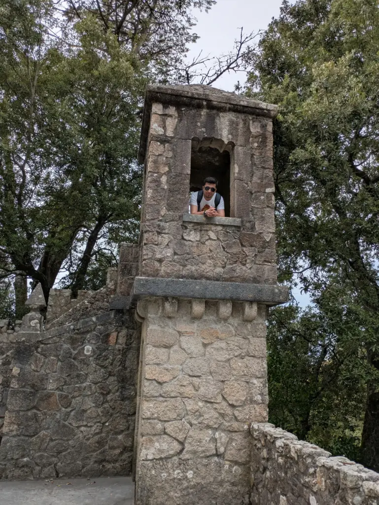 Ayal Othman leaning out of a stone tower window, combining historic perspective with a sense of forward thinking.